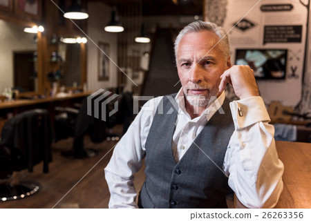 Old man sitting at bar counter and looking forward 26263356