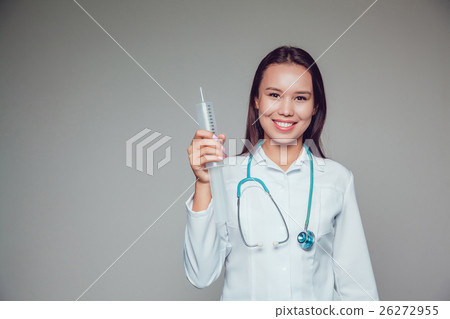 Smiling young woman doctor in white coat holding 26272955