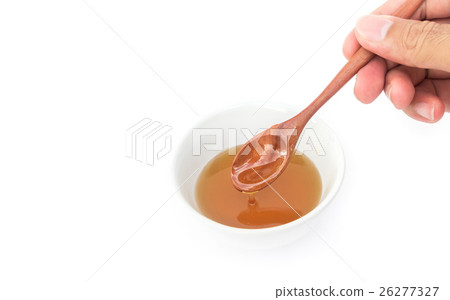 Closeup hand hold wooden spoon pour honey  26277327