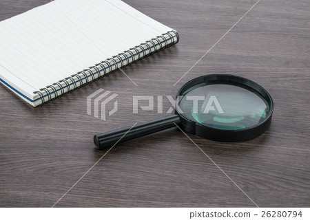 Blank notebook with Magnifier on the deskr 26280794