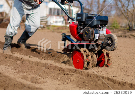 Man working in the garden with Garden Tiller 26283059