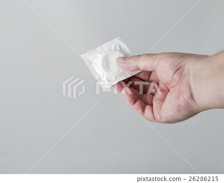 Hand holding a condom on white background Hand holding a condom on white background 26286215