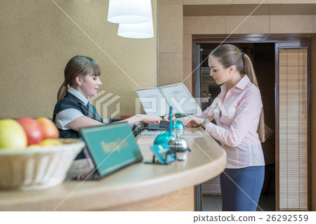 Businesswoman registers on arrival in hotel 26292559