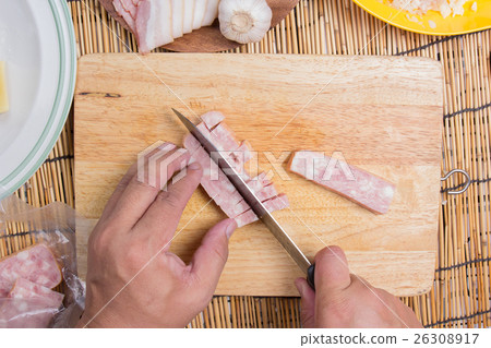Chef cutting bacon with knife before cooking 26308917