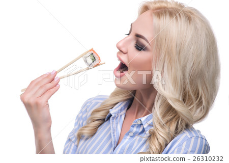 Beautiful girl holding sushi with a chopsticks Beautiful girl holding sushi with a chopsticks 26310232
