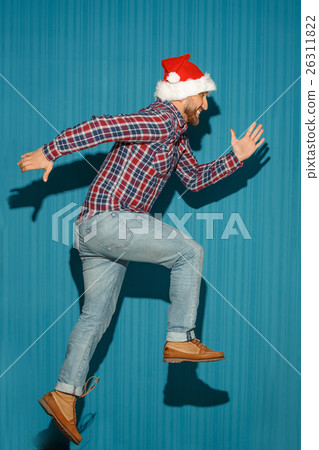 The running christmas man wearing a santa hat 26311822