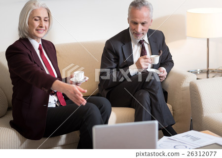 Happy businesswoman drinking coffee with her Happy businesswoman drinking coffee with her 26312077