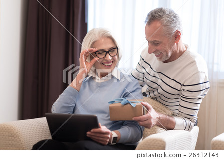 Smiling aged man giving a present to his wife 26312143