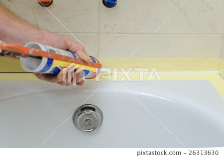 Worker puts silicone sealant. 26313630