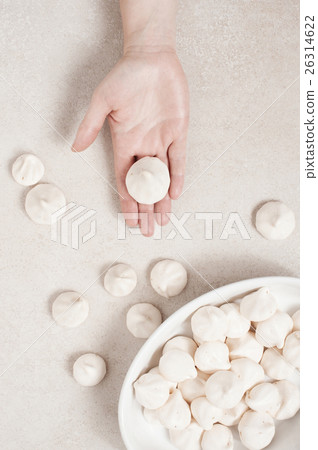 Hand holds white meringue 26314622