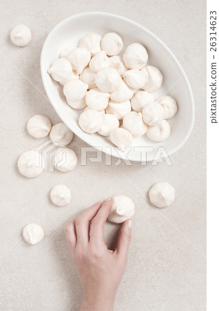 Hand holds white meringue 26314623