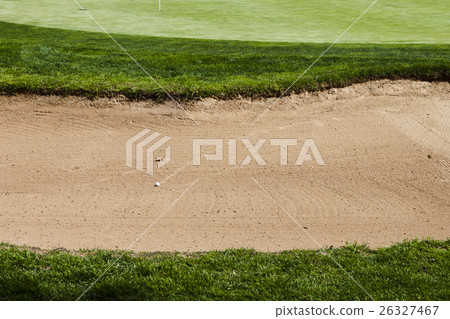 Golf ball on a bunker sand trap hazard. Golf ball on a bunker sand trap hazard. 26327467