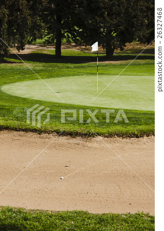 Golf ball on a greenside bunker sand trap hazard Golf ball on a greenside bunker sand trap hazard 26327468