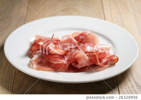 speck slices on white plate on old wood table 26328956