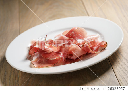 speck slices on white plate on old wood table 26328957