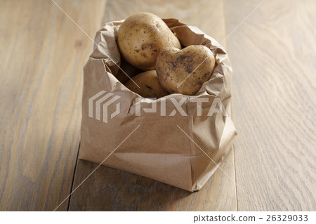 fresh potatoes in kraft paper bag on oak table 26329033