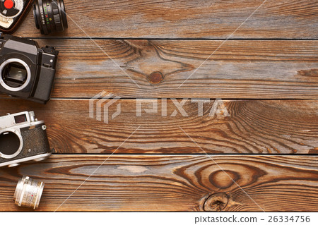 Vintage cameras and lenses on wooden background 26334756