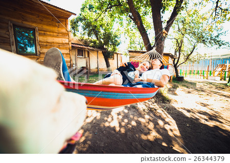 Pregnant woman and husband, resting in a hammock 26344379