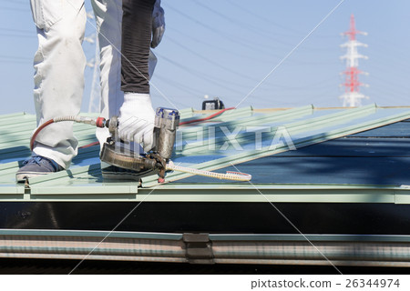 在屋頂鍍鋁鋅鋼板上用釘槍擊打釘子的工作 26344974