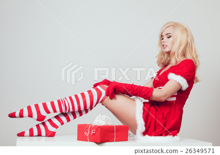Beautiful blonde snow maiden with gift sits and Beautiful blonde snow maiden with gift sits and 26349571