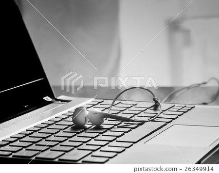 Earphone on the keyboard laptop. 26349914