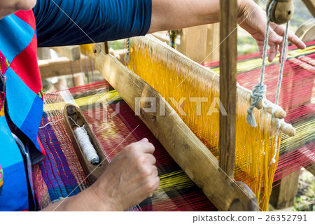 Weaving on a wooden loom 26352791