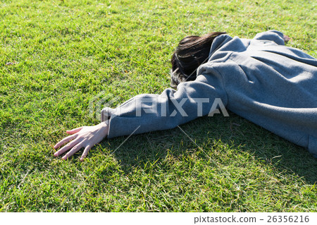A lady sleeping on the lawn on his stomach 26356216
