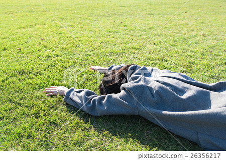 A lady sleeping on the lawn on his stomach A lady sleeping on the lawn on his stomach 26356217