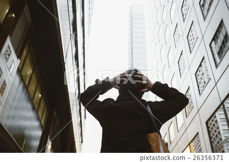A businessman holding a head 26356371