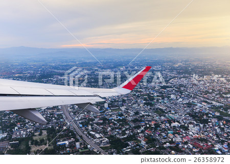 Wing of an airplane flying above the city 26358972