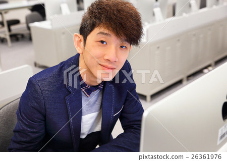 young man using computer in classroom 26361976