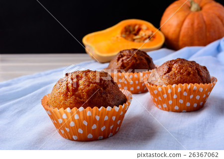 Pumpkin muffins in orange wrappers on blue napkin 26367062