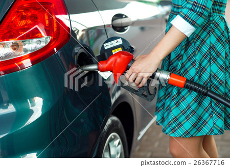 Woman fills petrol into the car at a gas station Woman fills petrol into the car at a gas station 26367716