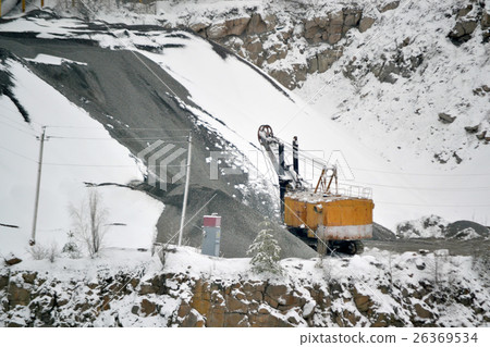 big huge yellow excavator in granite quarry winter big huge yellow excavator in granite quarry winter 26369534