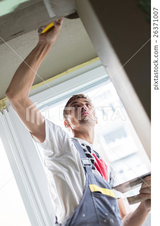 Plasterer renovating indoor walls and ceilings. 26371007