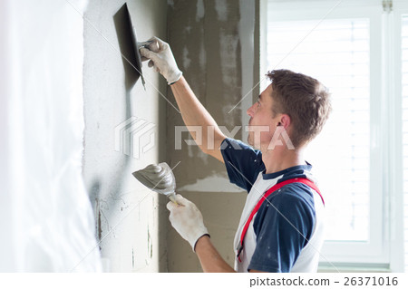 Plasterer renovating indoor walls and ceilings. 26371016