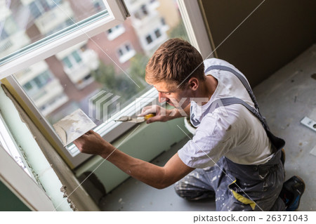 Plasterer renovating indoor walls and ceilings. 26371043