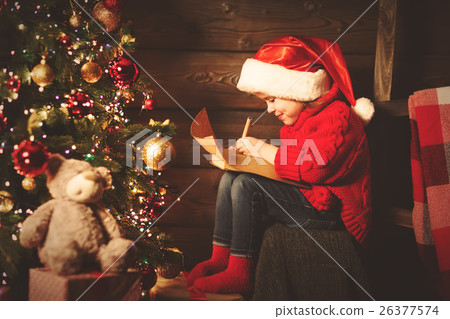 happy child girl writes letter to Santa Claus at the Christmas t 26377574