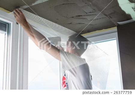 Plasterer renovating indoor walls and ceilings 26377759