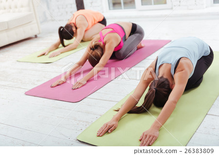 Three young girls doing group stretching workout Three young girls doing group stretching workout 26383809