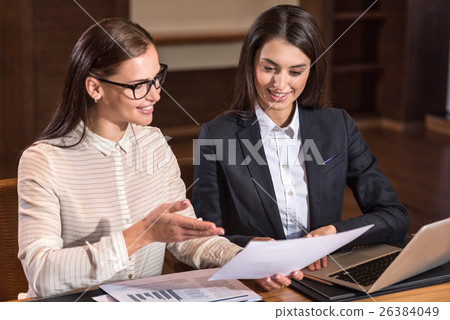 Joyful female colleagues discussing project in 26384049