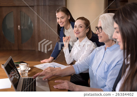 Ambitious colleagues using laptop in an office Ambitious colleagues using laptop in an office 26384402