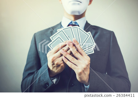 Businessman in mask holding a set of playing cards Businessman in mask holding a set of playing cards 26384411
