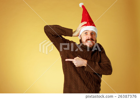 The serious christmas man wearing a santa hat The serious christmas man wearing a santa hat 26387376