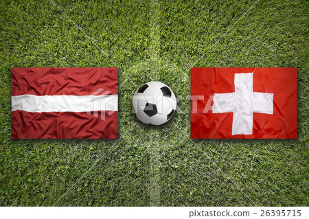 Latvia vs. Switzerland flags on soccer field Latvia vs. Switzerland flags on soccer field 26395715