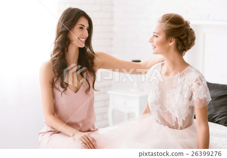 Delighted bridesmaid congratulates the bride with 26399276