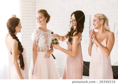 Smiling bride and bridesmaids having fun at home Smiling bride and bridesmaids having fun at home 26399319
