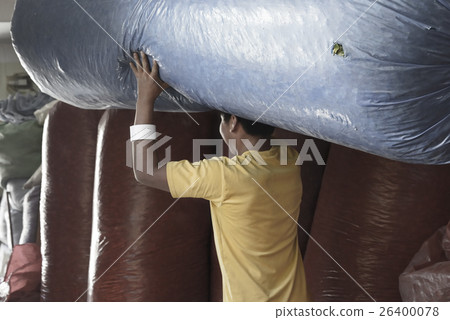 Worker moving out a large sack full of coca leaves Worker moving out a large sack full of coca leaves 26400078