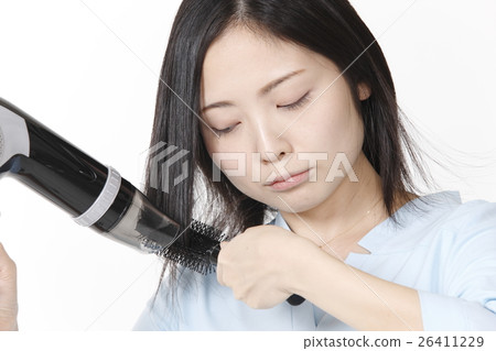 A young woman who arranges her hair A young woman who arranges her hair 26411229