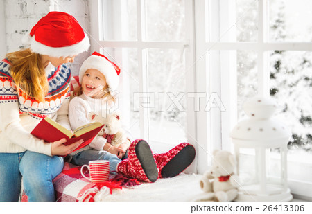 happy family mother and child daughter reading book on winter wi happy family mother and child daughter reading book on winter wi 26413306